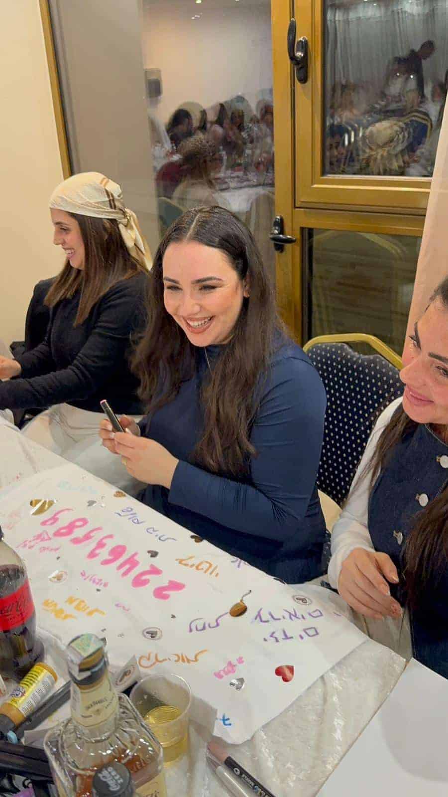 מיכל גרין צוחקת וחוגגת עם משתתפות בערב חגיגי